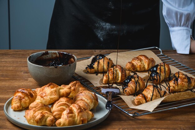 Croissants with chocolate and sprinkles on a wooden table.