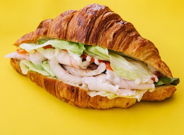 Croissantsandwich ham op gele achtergrond