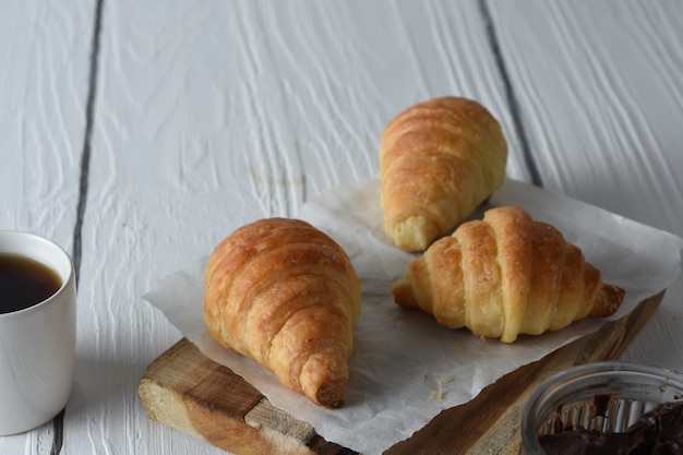 croissantVersgebakken croissants op een dienblad met een klein potje jam als ontbijt