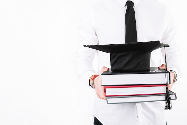 Crop alumnus with books and cap