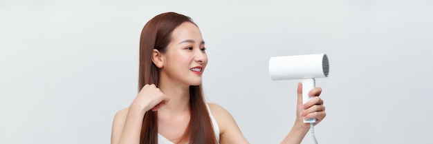 Crop attractive young female holding blow dryer on white banner background