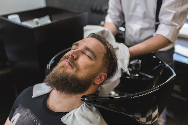 Crop barber wiping hair of customer