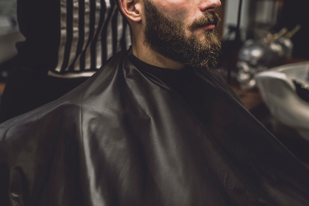 Crop customer and barber in salon