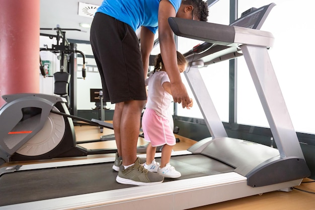 Photo crop dad exercising with daughter on treadmill