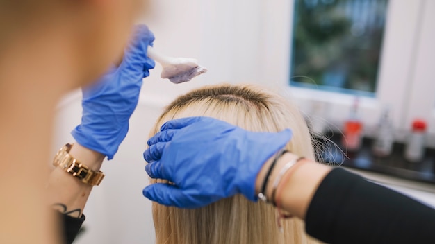 Photo crop hairdresser applying colorant