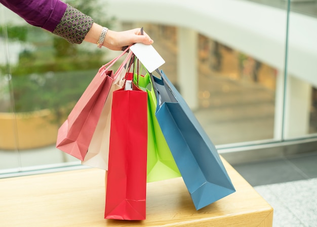 Crop hand holding shopping bags and plastic card