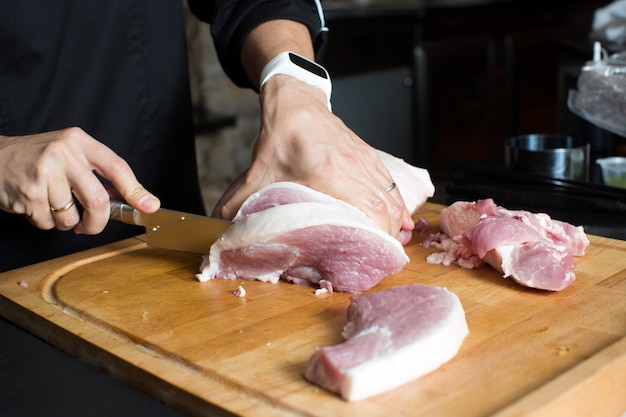 Foto ritaglia le mani tagliando la carne