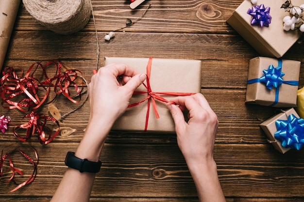 Crop hands decorating present