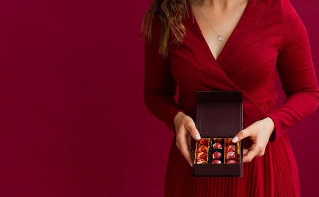 Photo crop of little box of bonbons in female hands female taking chocolate candy in little box