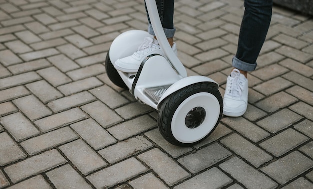 Crop male stepping on white gyroscooter