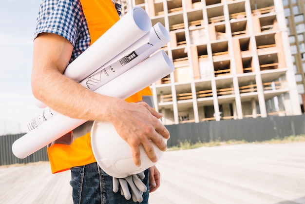 Photo crop man carrying drafts and helmet