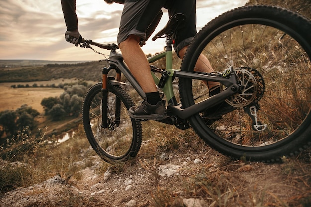 Crop man riding mountain bike