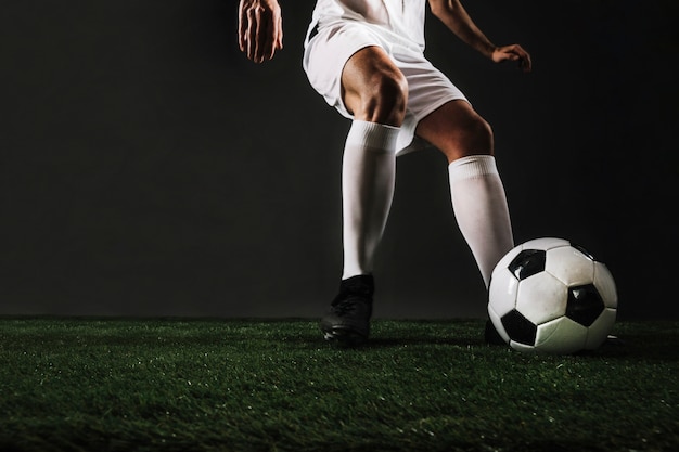 Foto ritaglia l'uomo che corre per calciare la palla