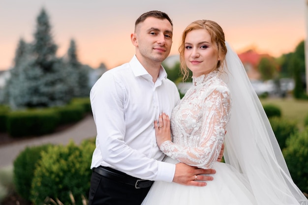 Crop Of Newlyweds In Wedding Outfits Posing Outdoors