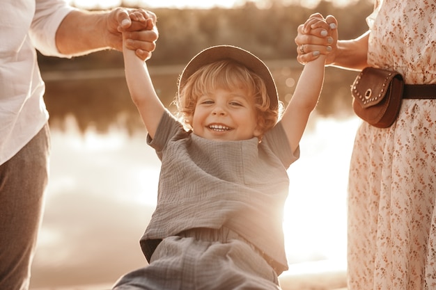 Photo crop parents playing with son on lakeshore