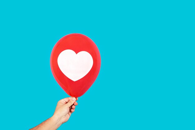 Crop person with balloon with heart