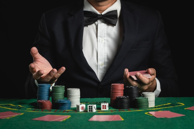 Crop picture of close up man dealer or croupier shuffles poker cards betting in casino on black background of green table Dealer man invitation bet playing cards Casino poker poker game concept