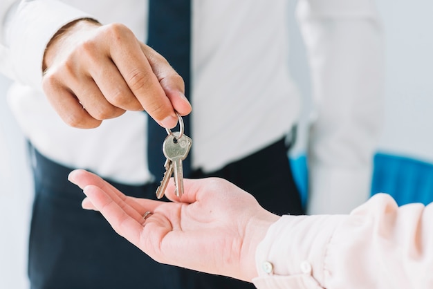 Foto raccolto agente immobiliare che fornisce le chiavi alla donna