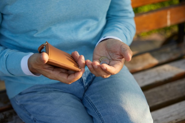 Crop shot of male hands counting money coins from the wallet