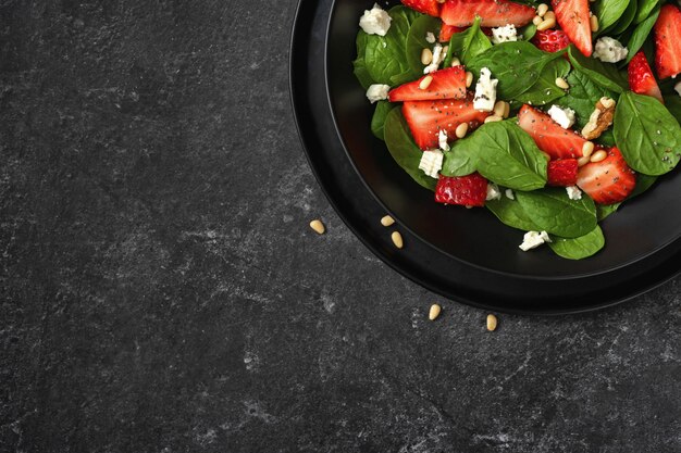 Crop shot of a plate with healthy vegetarian strawberry spinach salad