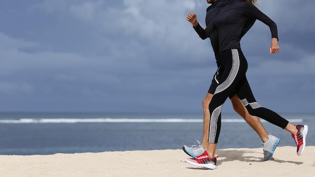 Crop shot of yong couple running on the beach