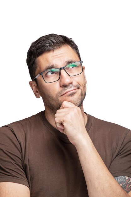 Photo crop shot of young handsome man with glasses wearing brown t-shirt thinking worried about a question