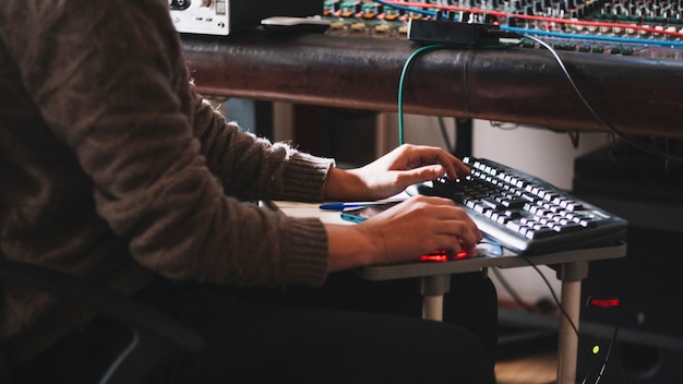 Crop sound engineer working at studio