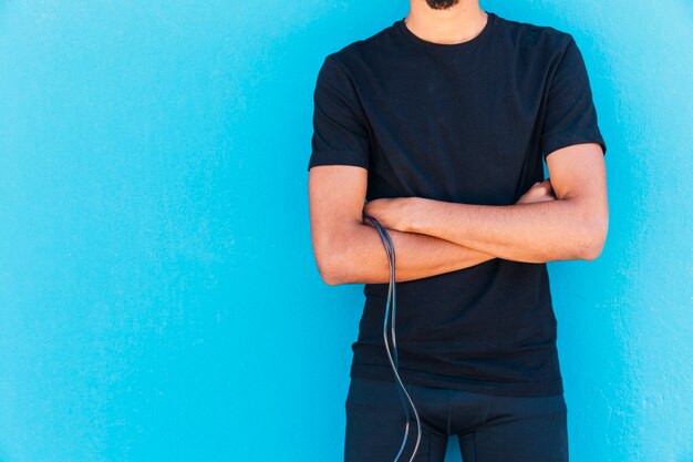 Crop sportive man with rope holding arms crossed 