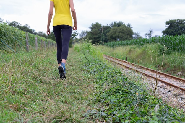 Crop sportswoman strolling near railway tracks during outdoor workout