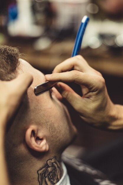 Crop stylist shaving client