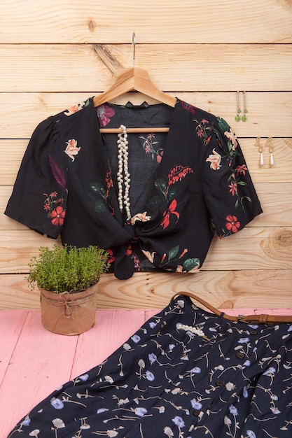 crop top blouse op hanger blauwe rok riem en sieraden haar parel clip ketting oorbellen