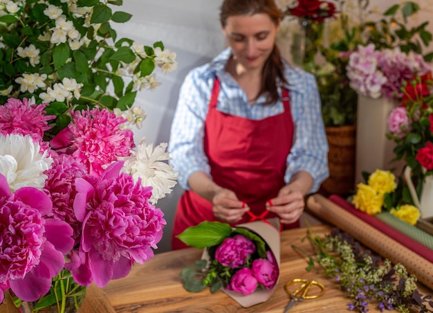 Crop view glazen vaas met bloeiende pioenrozen de verkoper van bloemen Floristic business