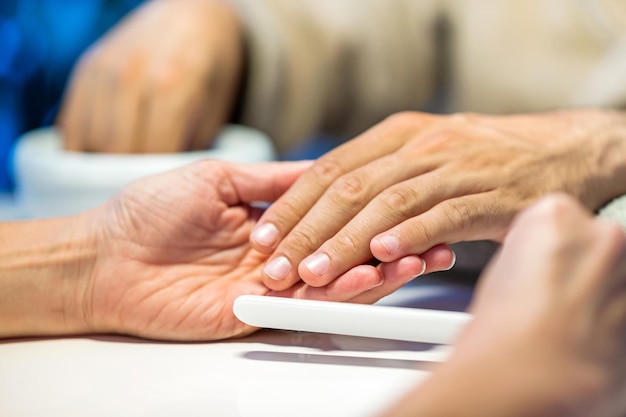 Photo crop woman doing manicure to man