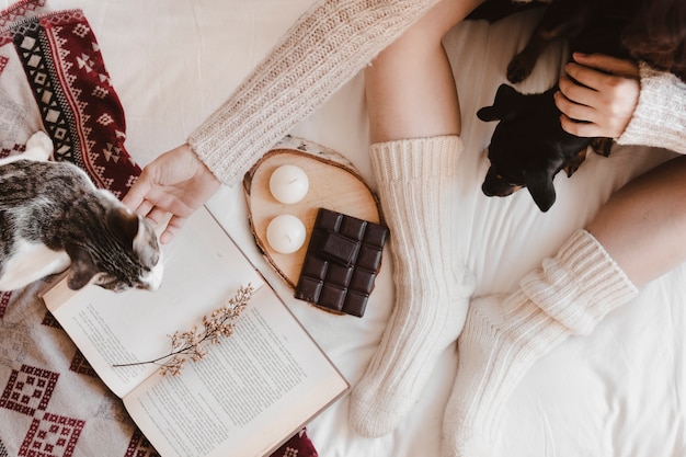 Foto il cane e il gatto di coccole della donna del raccolto vicino al libro