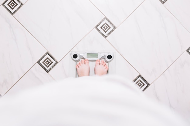 Photo crop woman standing on weight scale