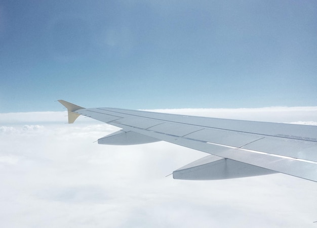 cropped airplane flying over cloudscape against sky