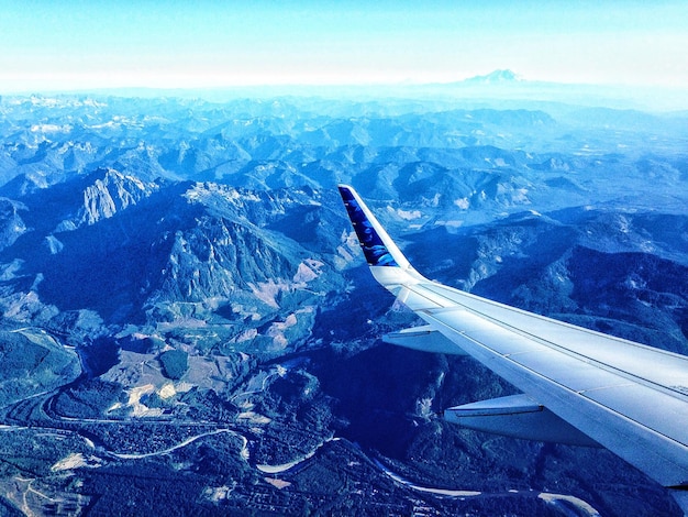 写真 山の上を飛ぶカットされた飛行機