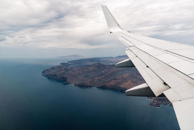 Cropped airplane flying over sea against sky