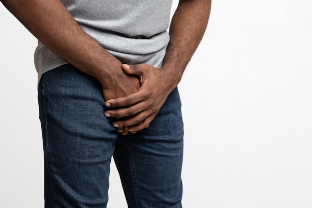 Photo cropped of black guy holding his groin