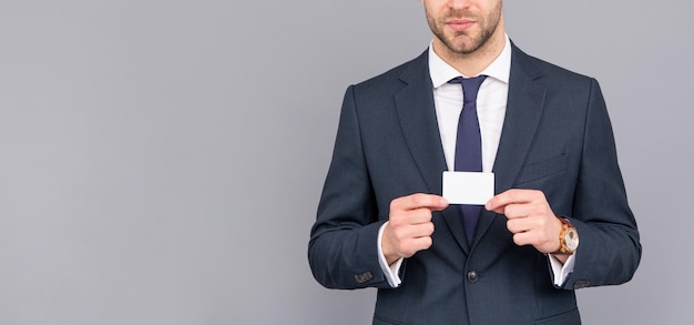 Cropped businessman hold credit card with copy space on grey background, banking