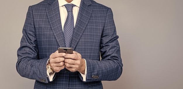 Cropped businessman man in suit typing text message on phone copy space business communication