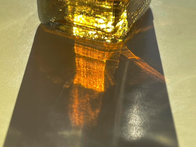 Cropped close up of sunlight shining through bottle with yellow liquid