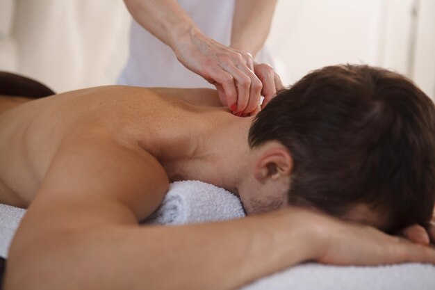 Photo cropped close up of unrecognizable man getting professional massage at spa center