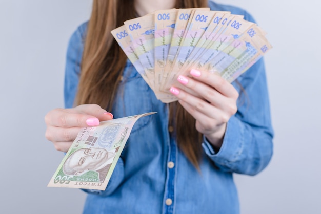 Cropped closeup photo of rich wealthy lady businesswoman holding pile stack of money in hands isolated grey background