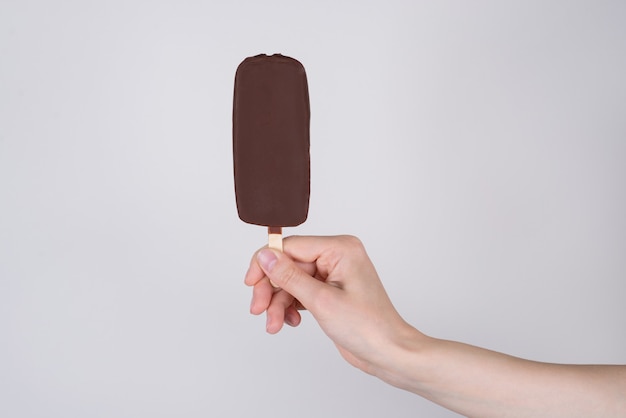 Cropped closeup side profile view photo of hand showing bougth in cafe restaurant tasty delicious yummy ice cream isolated grey background copyspace