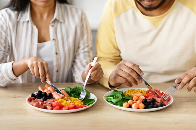 Photo cropped of couple sitting at table eating breakfast