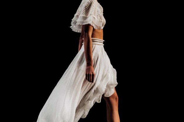 흰색 디자이너 의상을 입고 패션쇼를 걷고 있는 패셔너블한 모델의 자른 모습