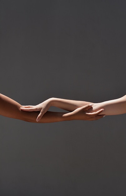 Photo cropped friends holding hands against gray background