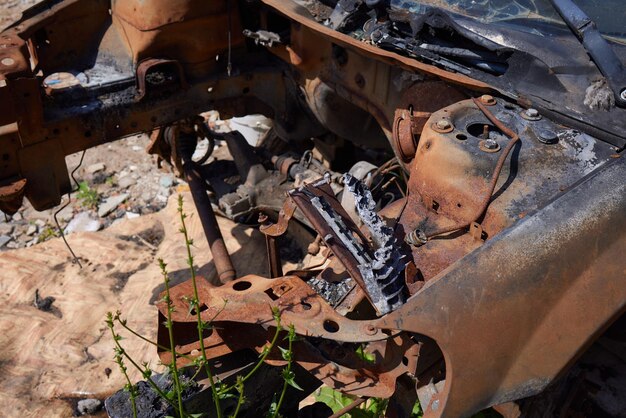 Foto una vista frontale ritagliata di un furgone arrugginito bruciato e abbandonato e di un faro rotto