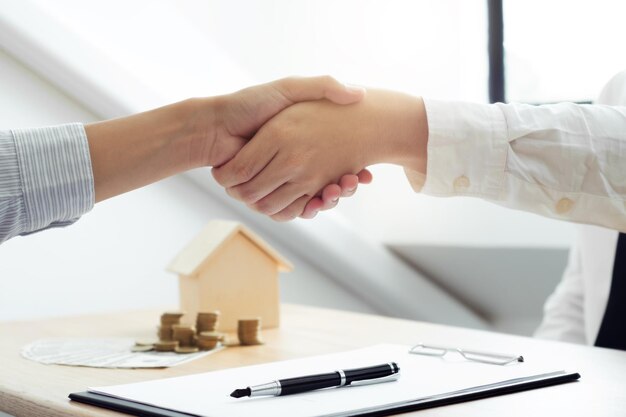 Foto mano tagliata di un agente che stringe la mano a un cliente in ufficio